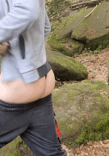 skinny guy is shaking his ass in a thong in the forest